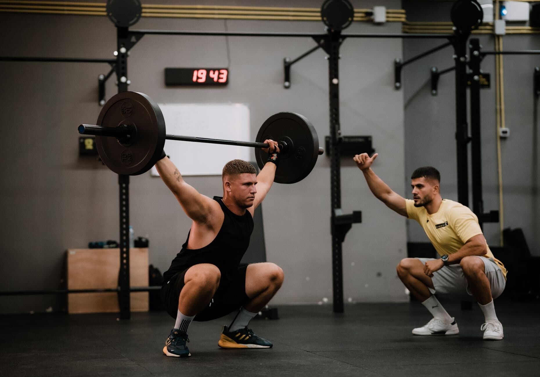 Coach guiding a lifter through an overhead squat